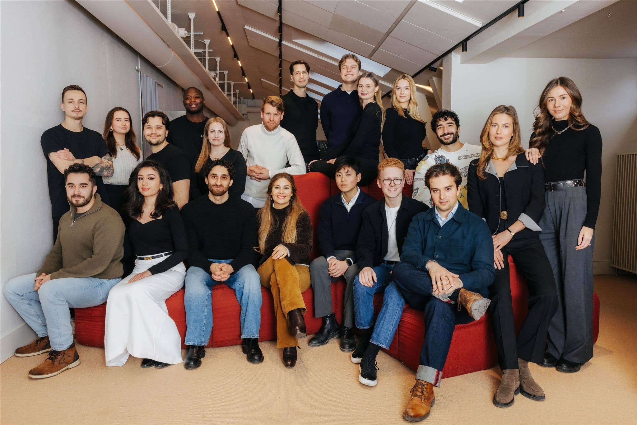 Gruppfoto av Shace-teamet och partners i en ljus kontorsmiljö med en röd soffa.